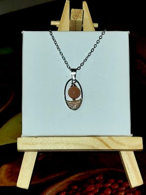 Collier Goutte Pierre de Soleil de Perle et Coquette : pendentif ovale en acier avec perle de pierre de soleil naturelle et résine corail pailletée.