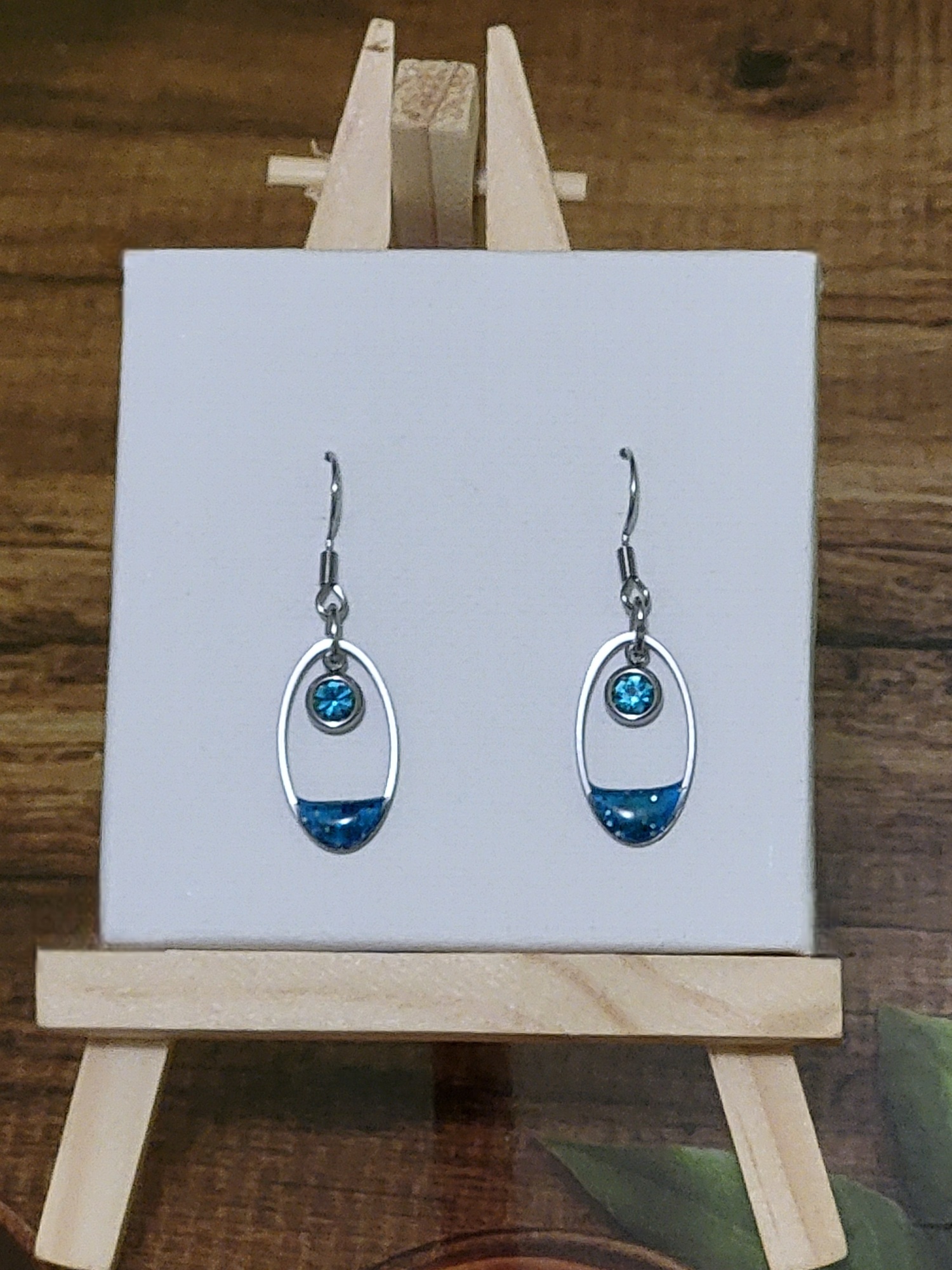 Boucles d’oreilles bleues en acier inoxydable avec résine pailletée et cristal bleu – création artisanale Perle et Coquette